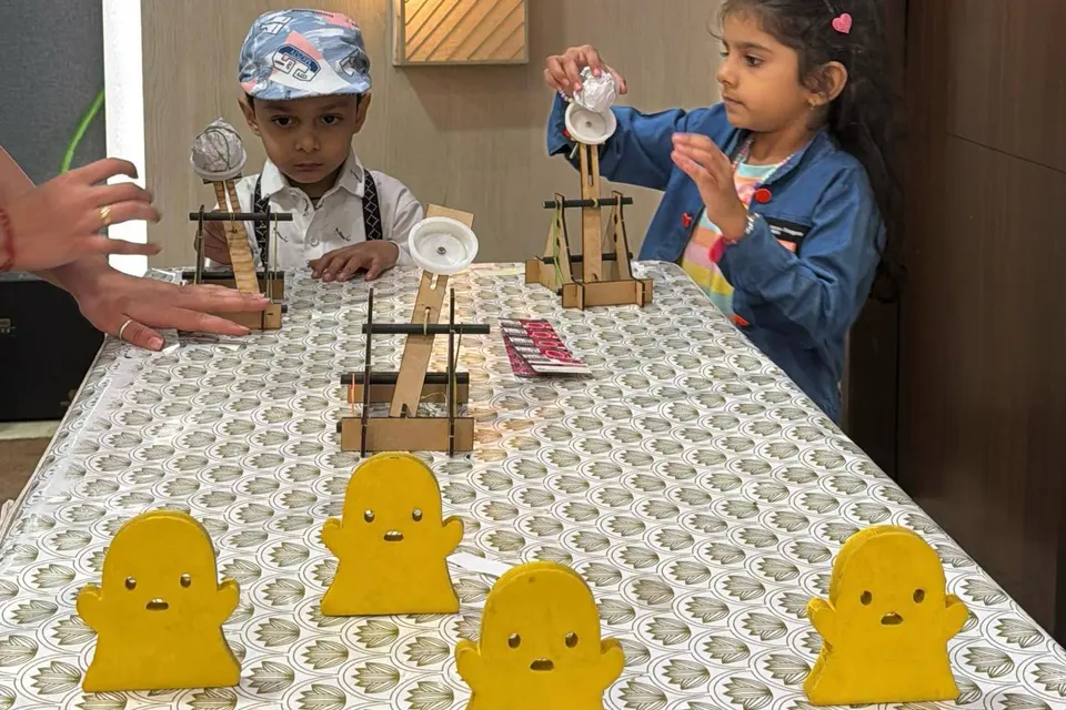 Children at a long table lined with wooden target stands