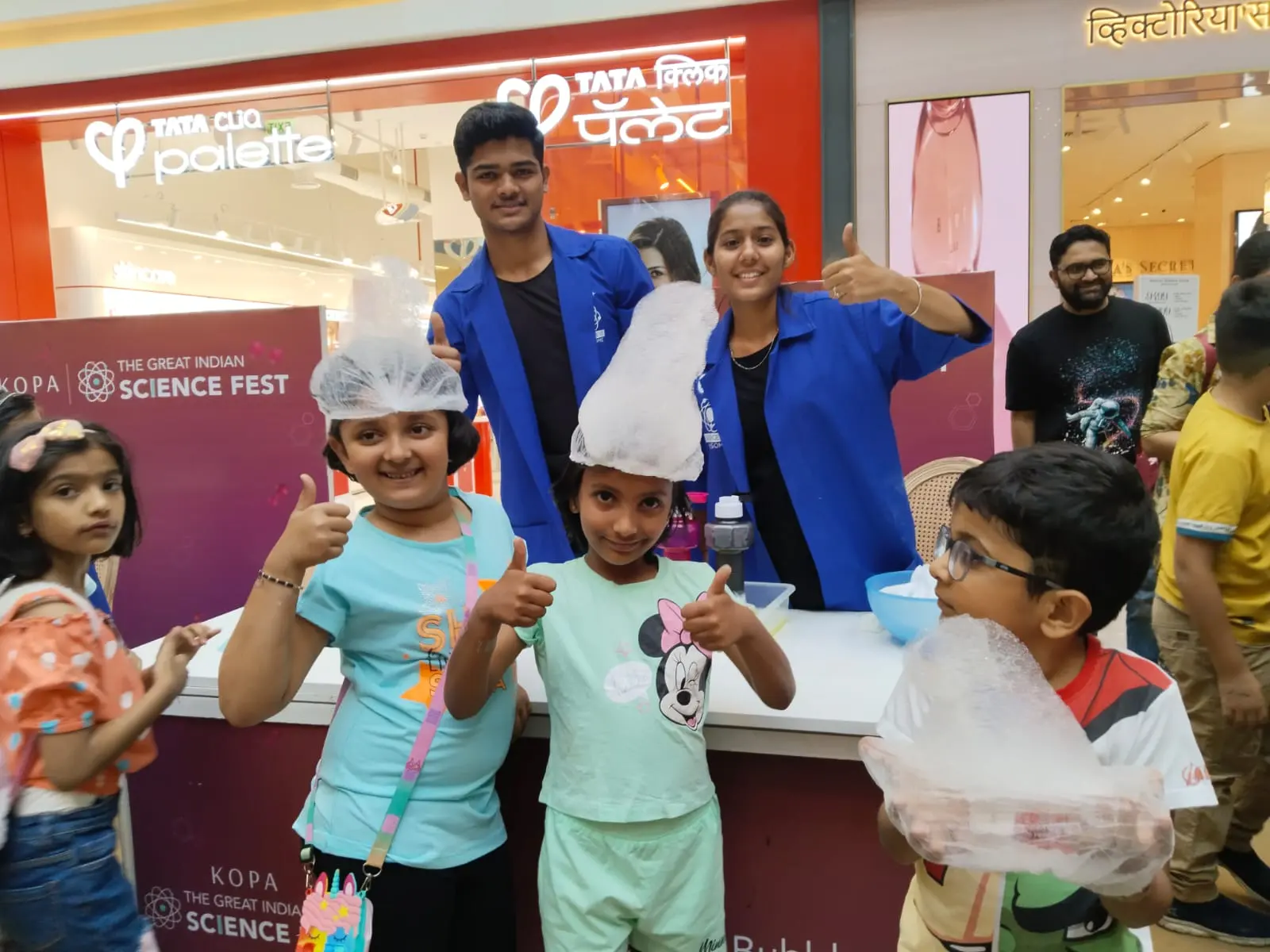 Children giving a thumbs-up in foam hats with MakerMasti hosts at The Great Indian Science Fest, KOPA Mall, Pune