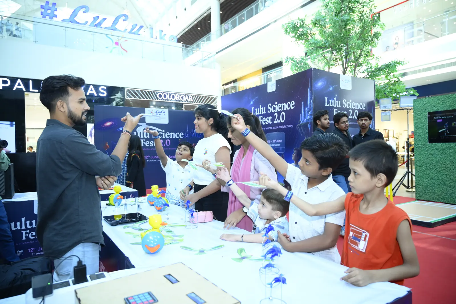 Children launching paper gliders with a MakerMasti host at Lulu Science Fest 2.0, Lulu Mall, Lucknow