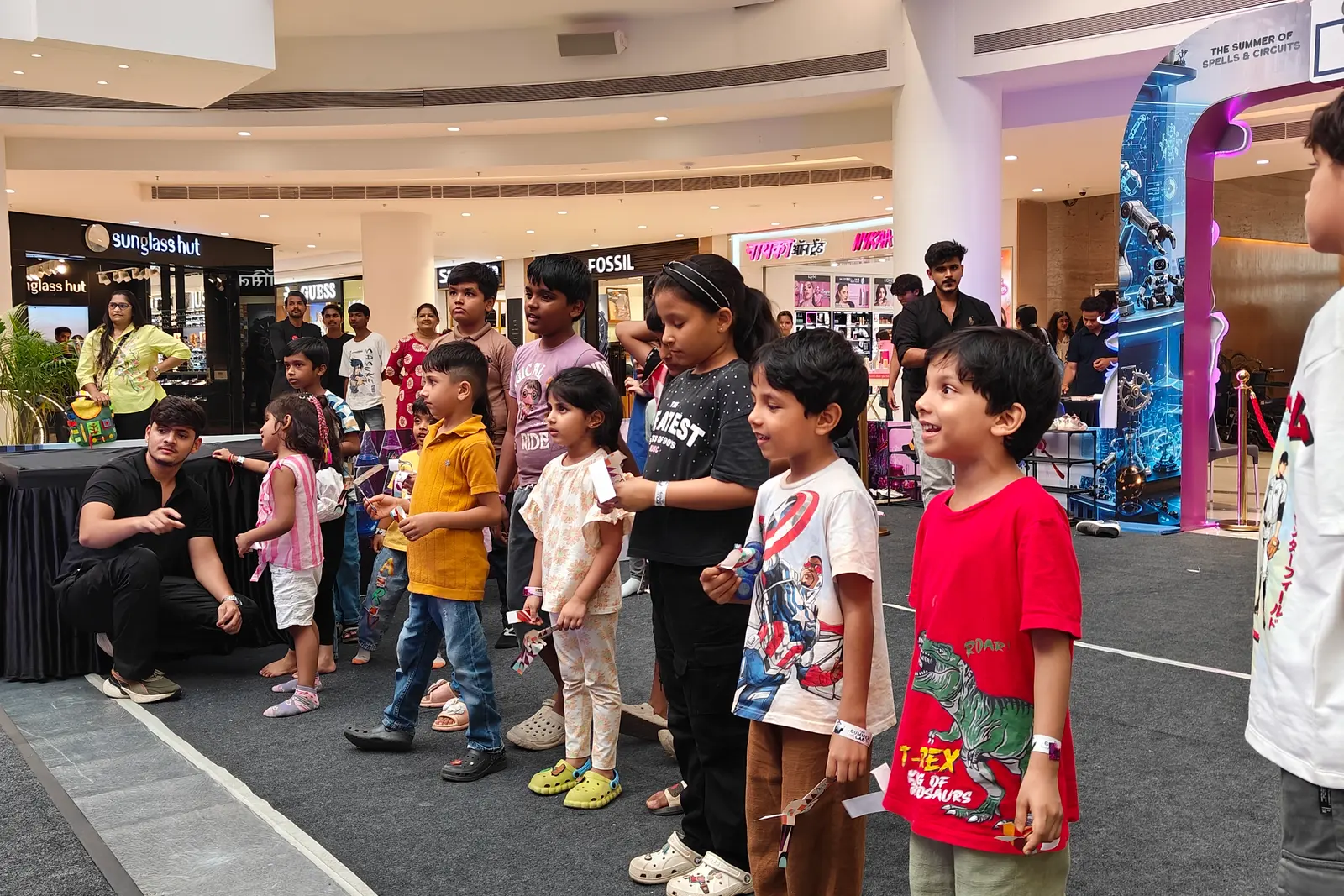 Children queueing along a mall concourse for a MakerMasti activity