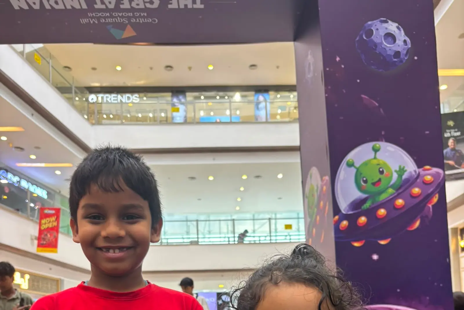 A boy and a girl holding up the paper gliders they have just made