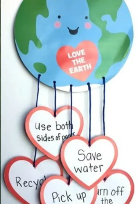 Children writing pledge on leaf shaped cutouts