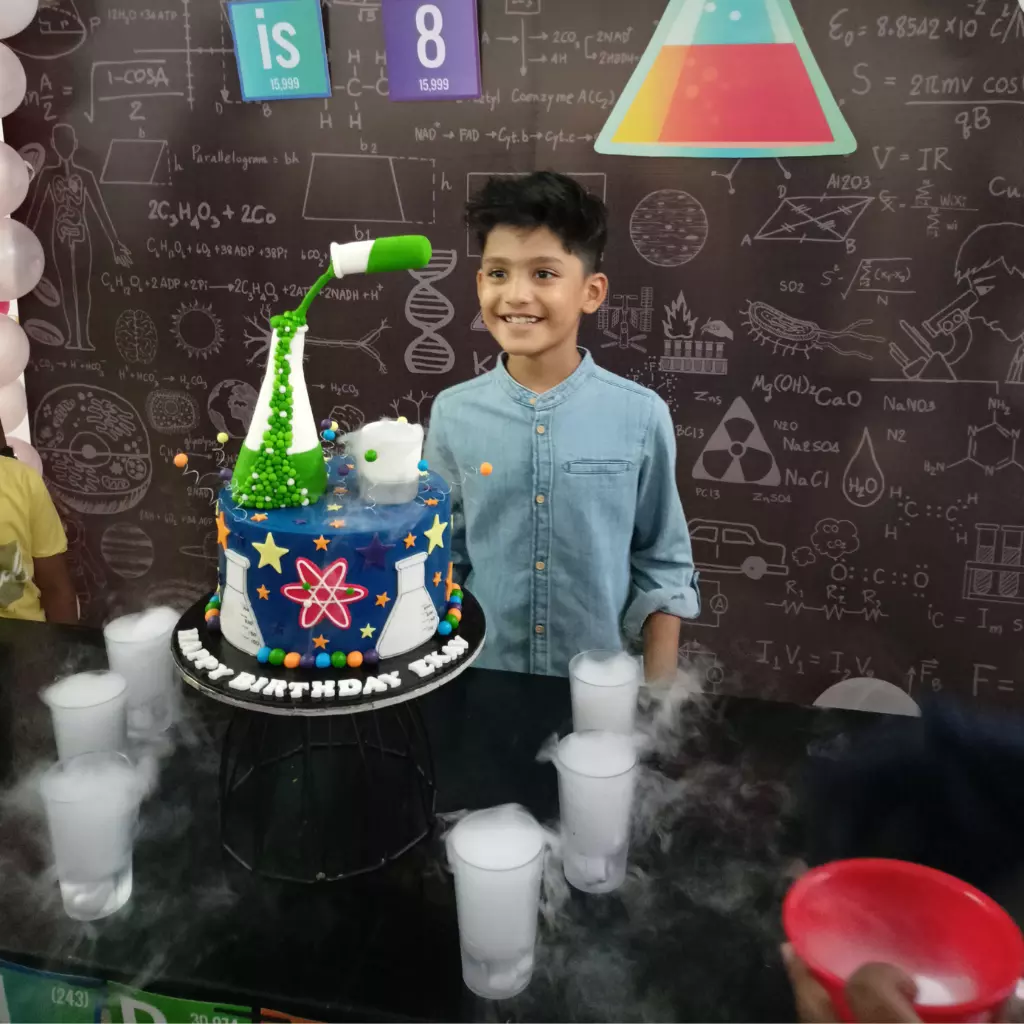 birthday child standing infront of Science themed cake